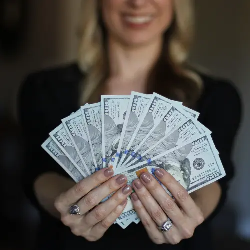 Una mujer mostrando una paca de billetes