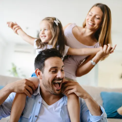 Padres jugando con su hija en una habitación